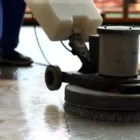 Industrial cleaning company using cleaning equipment to scrub a floor.